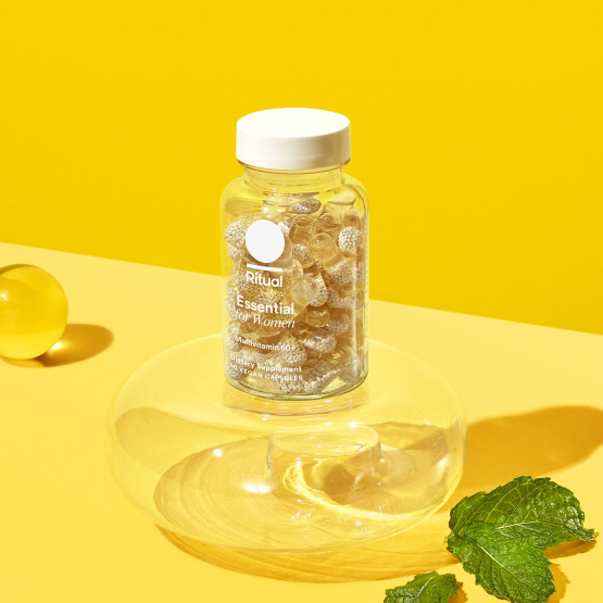Essential for Women 50+ Multivitamin Bottle staged against yellow backdrop