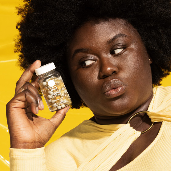 Woman holding Ritual's multivitamin 18+